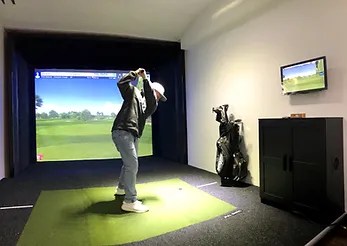 guest swinging at a golf simulator